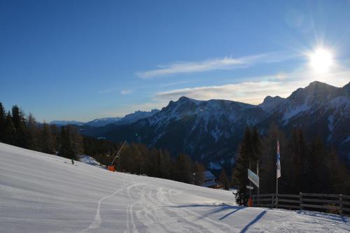 a snow covered ski slope with the sun in the background at Rifugio Graziani Hütte in San Vigilio Di Marebbe
