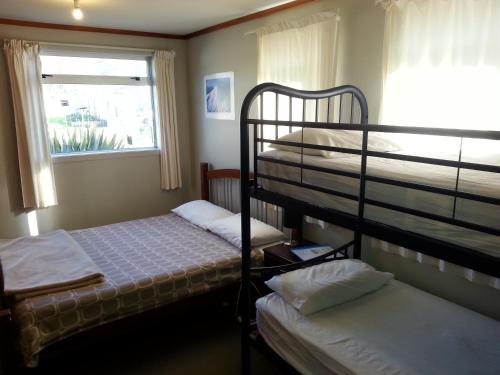 a bedroom with two bunk beds and a window at Riverstone Lodge in Turangi