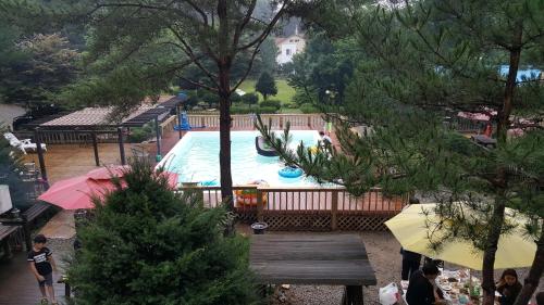 a pool in a yard with people standing around it at Shinevalley Pension & Hotel in Pyeongchang 