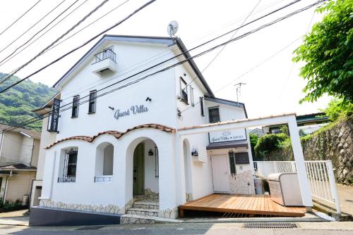a small white building with a wooden deck at Guest Villa Hakone Yumoto 101 in Hakone