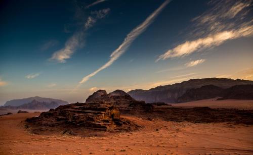 a view of the desert with mountains in the background at Wadi Rum Moon Light Camp in Wadi Rum