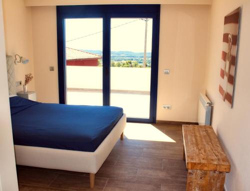 - une chambre avec un lit et une grande fenêtre dans l'établissement Manuki Mas, à Vall-llobrega