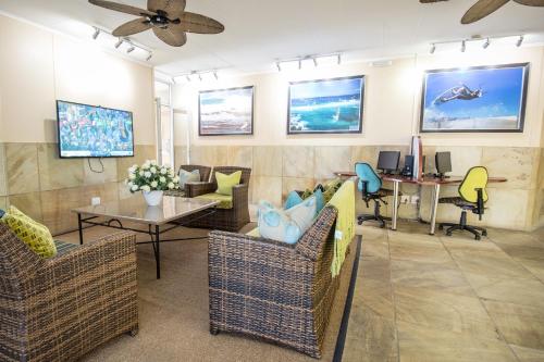 a living room with chairs and tables and a ceiling fan at First Group La Cote D'Azur in Margate