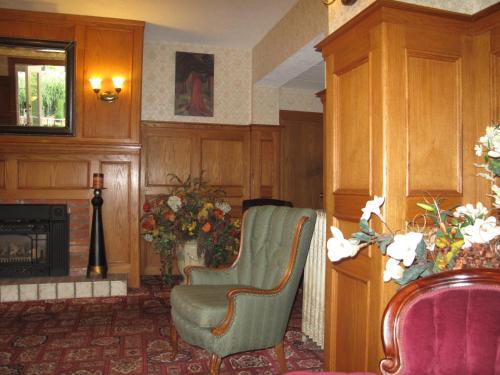 a living room with two chairs and a fireplace at James Bay Inn Hotel, Suites & Cottage in Victoria