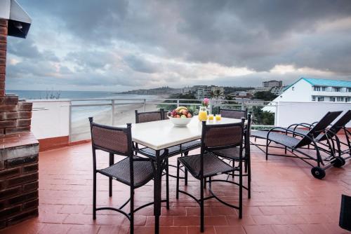 a table with chairs and a bowl of fruit on a balcony at First Group La Cote D'Azur in Margate