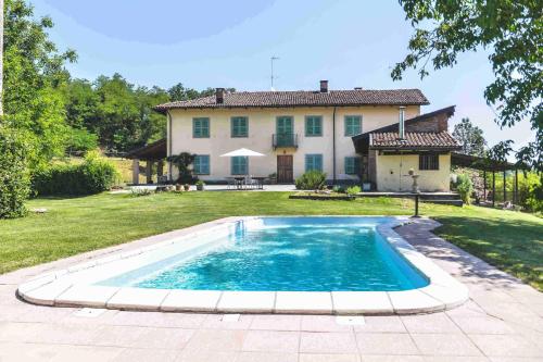 a swimming pool in front of a house at Cascina Lissona in Asti