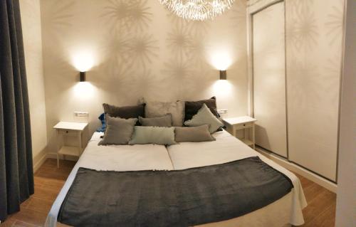 1 dormitorio con 1 cama grande con 2 mesas y lámpara de araña en Luxury Catedral, en Málaga