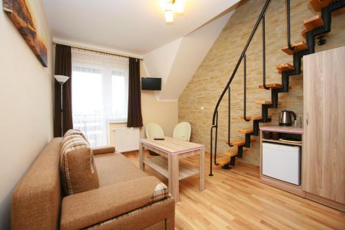 sala de estar con sofá y escalera en Willa Faro en Jastrzębia Góra