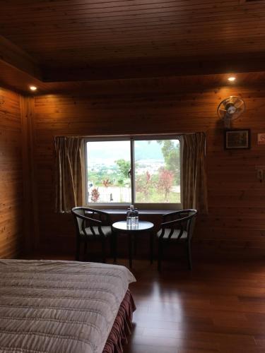 a bedroom with a bed and a table and a window at Yuli Sun Homestay in Yuli