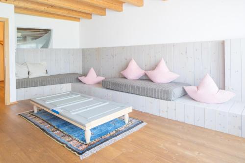 a room with two beds with pink pillows on them at Frida am Wald in Rasùn di Sotto