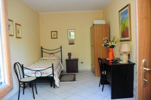 Affittacamere della Paolina في Ceccano: غرفة نوم بسرير وطاولة وكراسي