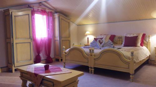 une chambre avec deux lits et une table et une fenêtre dans l'établissement Clos de l'Artuby, à Valderoure