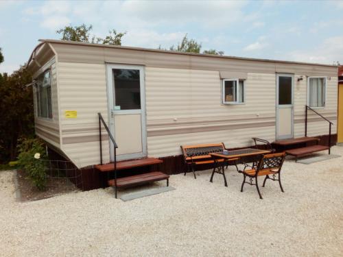 une caravane avec une table et des chaises en face de celle-ci dans l'établissement Domki Gucio i Maja, à Grodzisk Mazowiecki