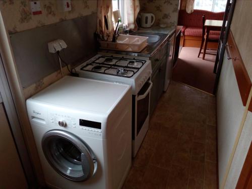 uma cozinha com um fogão e uma máquina de lavar roupa em Domki Gucio i Maja em Grodzisk Mazowiecki