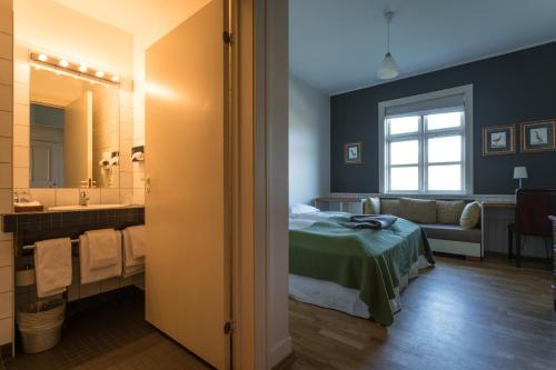 a bedroom with a bed and a bathroom with a mirror at Hotel Búdir in Búðir