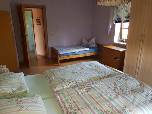 Un dormitorio con 2 camas y un banco. en Strasse des Friedens, en Hilmersdorf