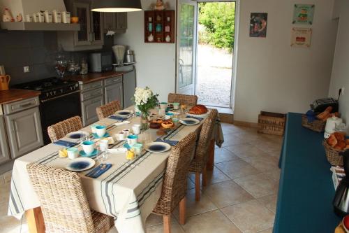 - une table dans une cuisine avec un ensemble de plats dans l'établissement La demeure d'Ervée, à Isigny-sur-Mer