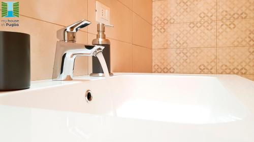 een wastafel in een badkamer met een kraan bij Borgo Guesthouse in Monopoli