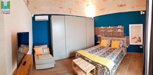 een slaapkamer met een bed en een blauwe muur bij Borgo Guesthouse in Monopoli