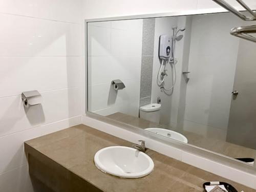 une salle de bain avec un lavabo et un miroir dans l'établissement Myangkasa Akademi & Resort Langkawi, à Pantai Cenang