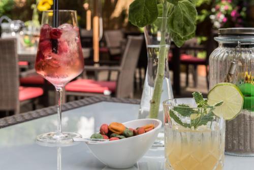 a table with a drink and a bowl of fruit at Bavaria Boutique Hotel in Munich