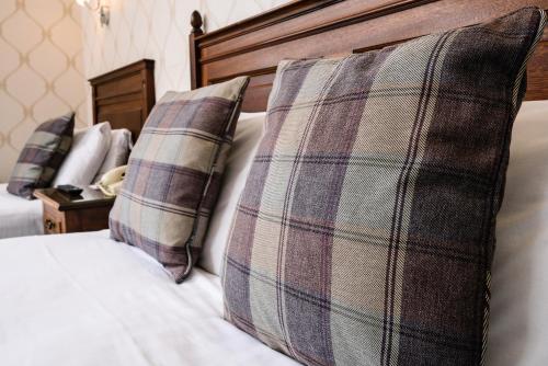 a bed with two pillows on top of it at The Atholl Palace in Pitlochry