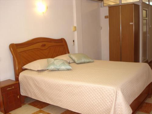 um quarto com uma cama com duas almofadas em Ebrahim Flats - Grand Baie Beach em Grand Baie