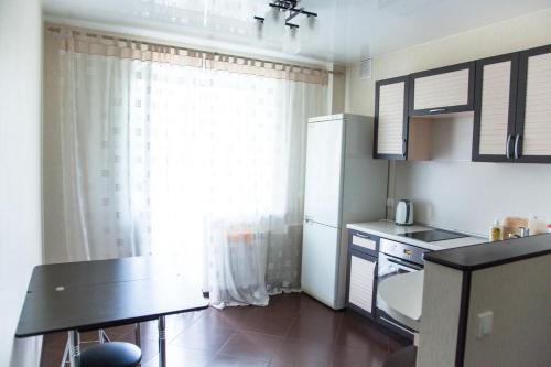 トムスクにあるАпартаменты Учебная 7の小さなキッチン(冷蔵庫、テーブル付)