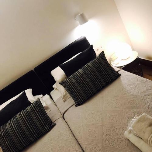 a bed with black and white pillows on it at Afroditi Arhontiko in Litochoro