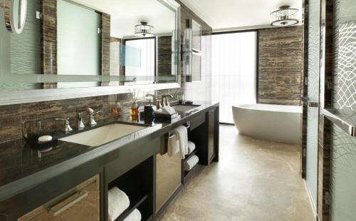 a bathroom with a tub and a sink and a bath tubermottermott at Four Seasons Hotel Abu Dhabi at Al Maryah Island in Abu Dhabi