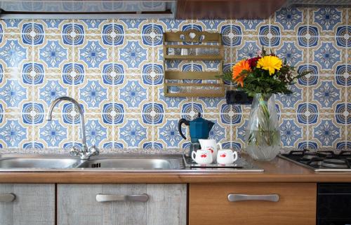 a kitchen with a sink and a vase of flowers at Resort Siranita in Ercolano