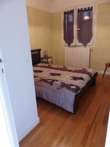 a bedroom with a bed and a wooden floor at Appartement L'Orel in Embrun