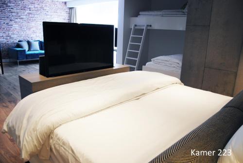 a bedroom with a bed with a flat screen tv at Van der Valk Hotel Assen in Assen