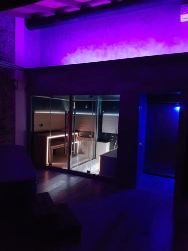 an empty room with purple lighting and a refrigerator at Corte Attilea in Valeggio sul Mincio