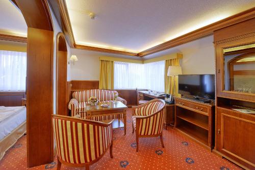 a hotel room with a bed and a living room at Parkhotel Stader Hof in Stade