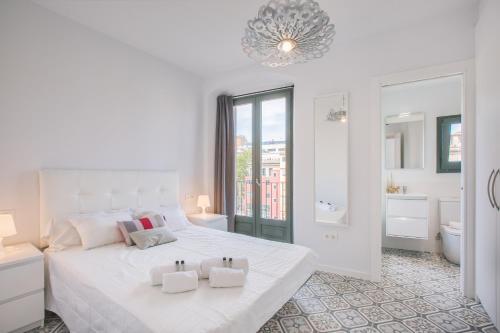 ジローナにあるFlateli Rambla 5 3-2の白いベッドルーム(大きな白いベッド1台付)、バスルームが備わります。