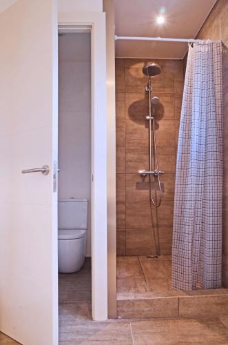 a bathroom with a shower with a toilet and a shower curtain at Manuki Mas in Vall-Llobrega