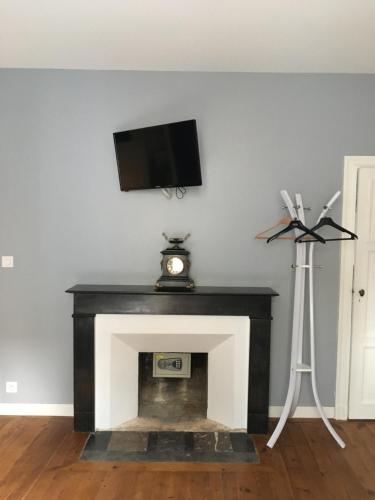 a living room with a fireplace with a tv above it at Villa Des Ursulines in Bayeux