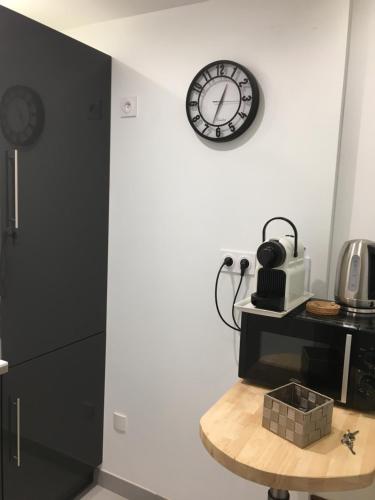 a room with a clock on the wall and a table at Villa Des Ursulines in Bayeux