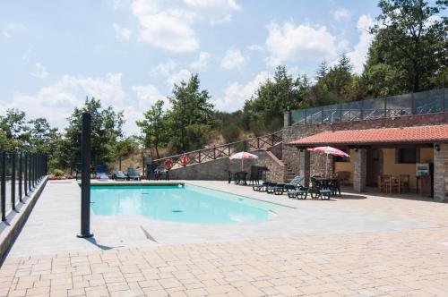 a swimming pool in a courtyard with a building at Hotel Da Giovanna in Chiusi della Verna