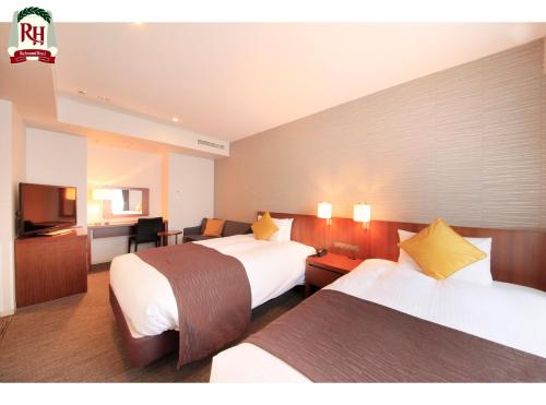 a hotel room with two beds and a television at Richmond Hotel Tokyo Shiba in Tokyo