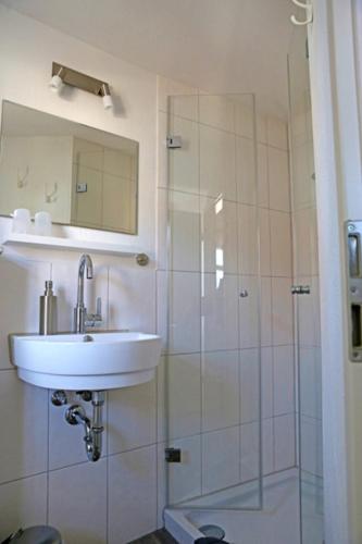 a bathroom with a sink and a shower at Pension Gute Stube in Sulzfeld