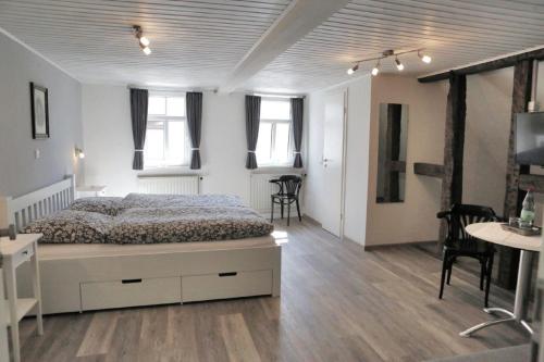 a bedroom with a bed and a table and chairs at Pension Gute Stube in Sulzfeld (im Grabfeld)