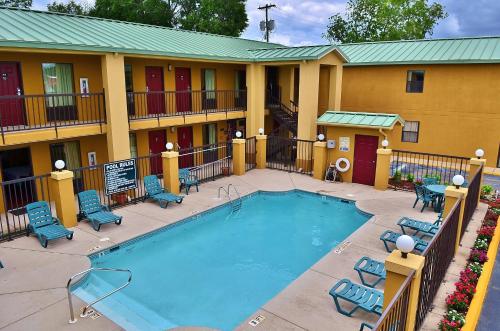 a pool at a hotel with chairs and a building at Executive Inn Opp in Opp