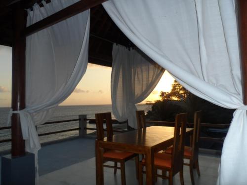 a table and chairs with a view of the ocean at Cafe Alberto B and B in Senggigi 