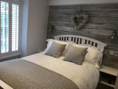 Un dormitorio con una cama blanca con una pared cardiaca en Riverside Suites Llangollen en Llangollen