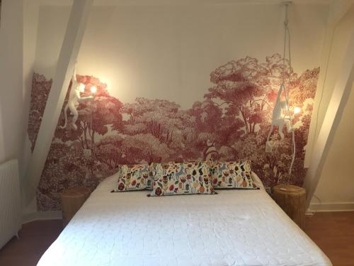 レ・ゼイジー・ド・タヤックにあるLa Maison Carrée - Villa de charme - Clim & Piscine chaufféeのベッドルーム1室(壁に絵画が描かれたベッド1台付)