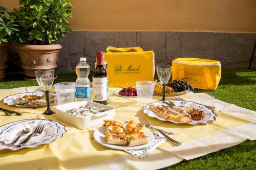 a table with plates of food and a bottle of wine at Hotel Villa Marsili in Cortona