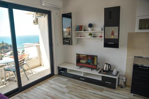 a living room with a tv and a balcony at Casa Bianca & Spa in Ulcinj