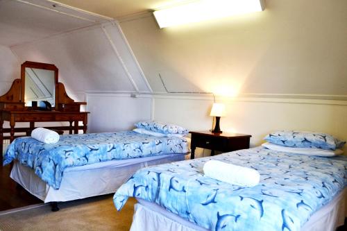 ein Zimmer mit zwei Betten und einem Spiegel in der Unterkunft 54 On Strand in Lambertʼs Bay